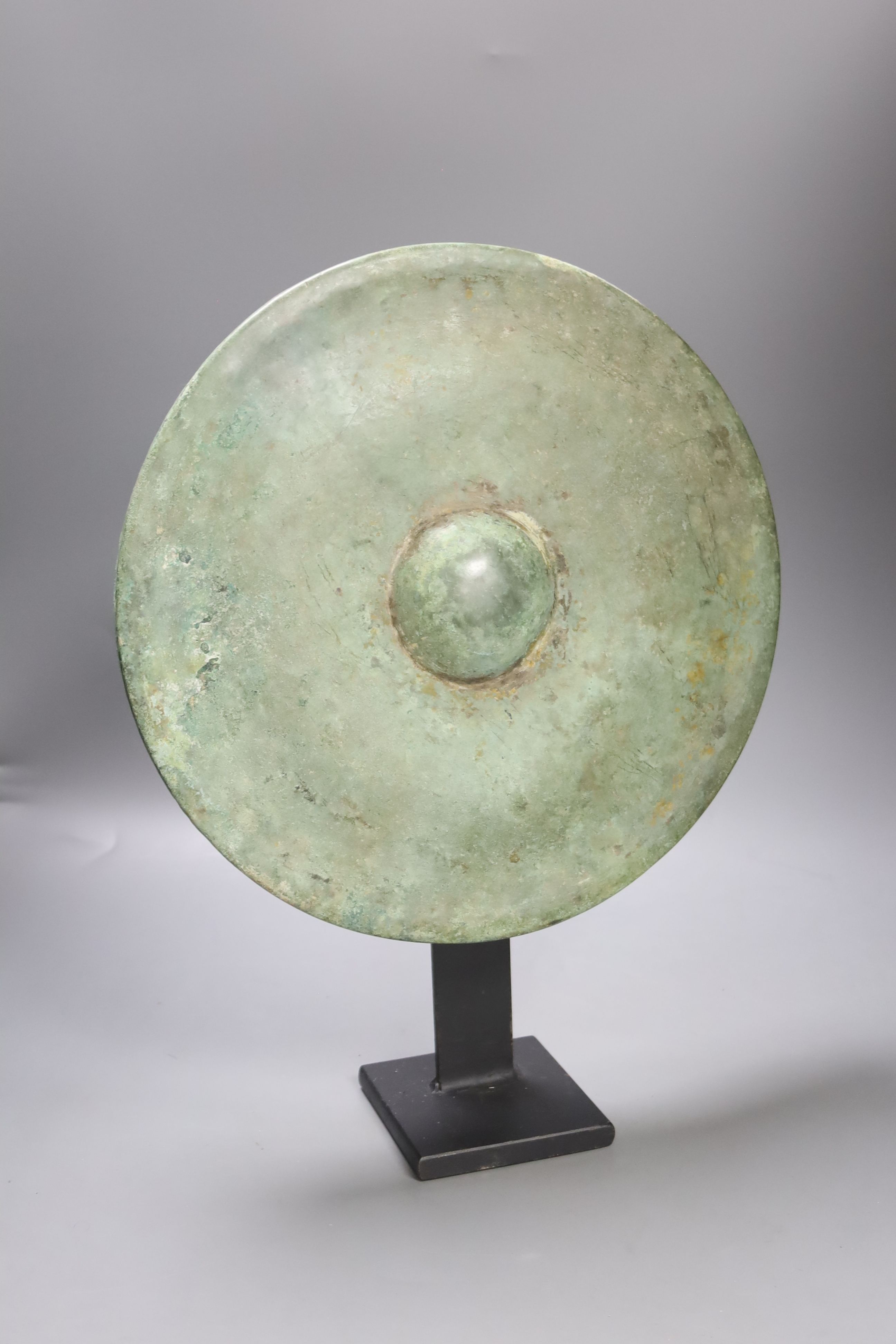 A Cambodian bronze gong, Khmer 12th/13th century, later metal stand 33cm diam